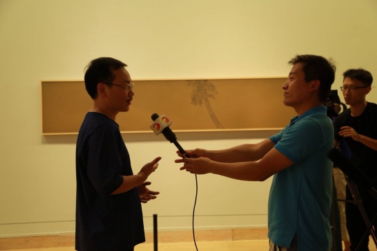 藝術家彭斯（左）在展覽現(xiàn)場接受媒體采訪
